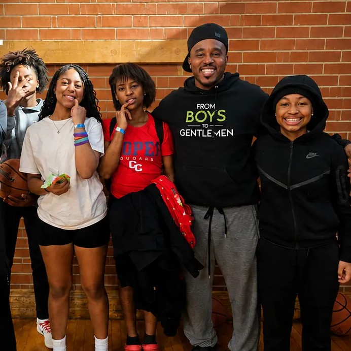 Students and their mentor together in the school gym.